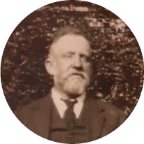 Elderly man with beard in suit and tie looking straight ahead.